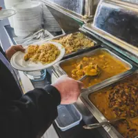 Volunteers prepare steaming meals for guests at The Open Kitchen