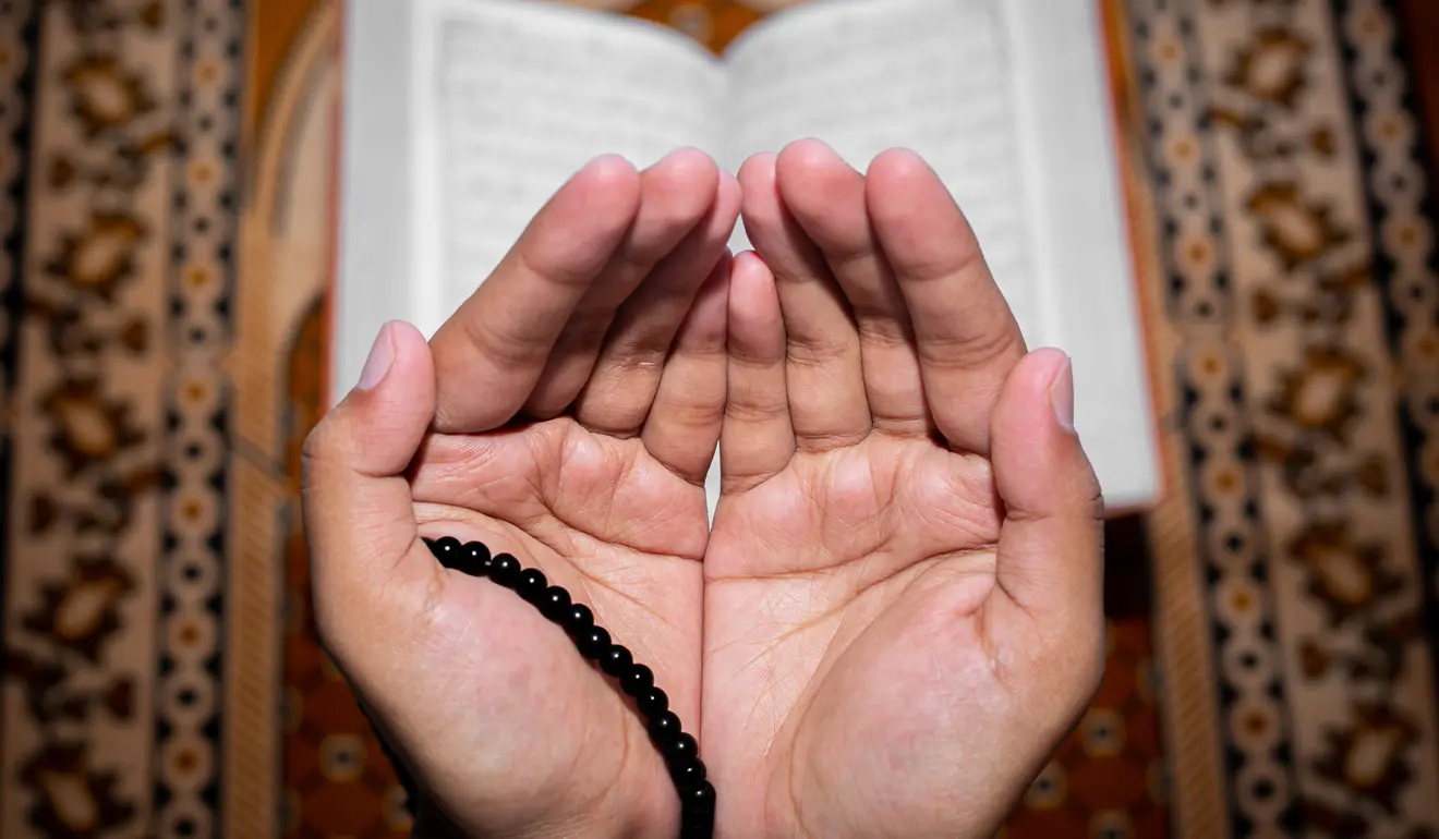 palms making dua supplication with tasbeeh prayer beads