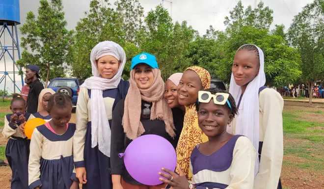 Salma, a Muslim Hands volunteer poses with a group of child beneficiaries. 