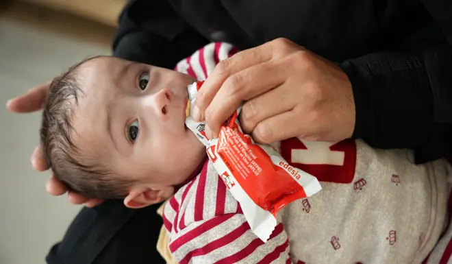 Omar receiving a highly nutritious bar to help fight malnutrition. 