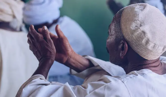Man raises his hands in prayer